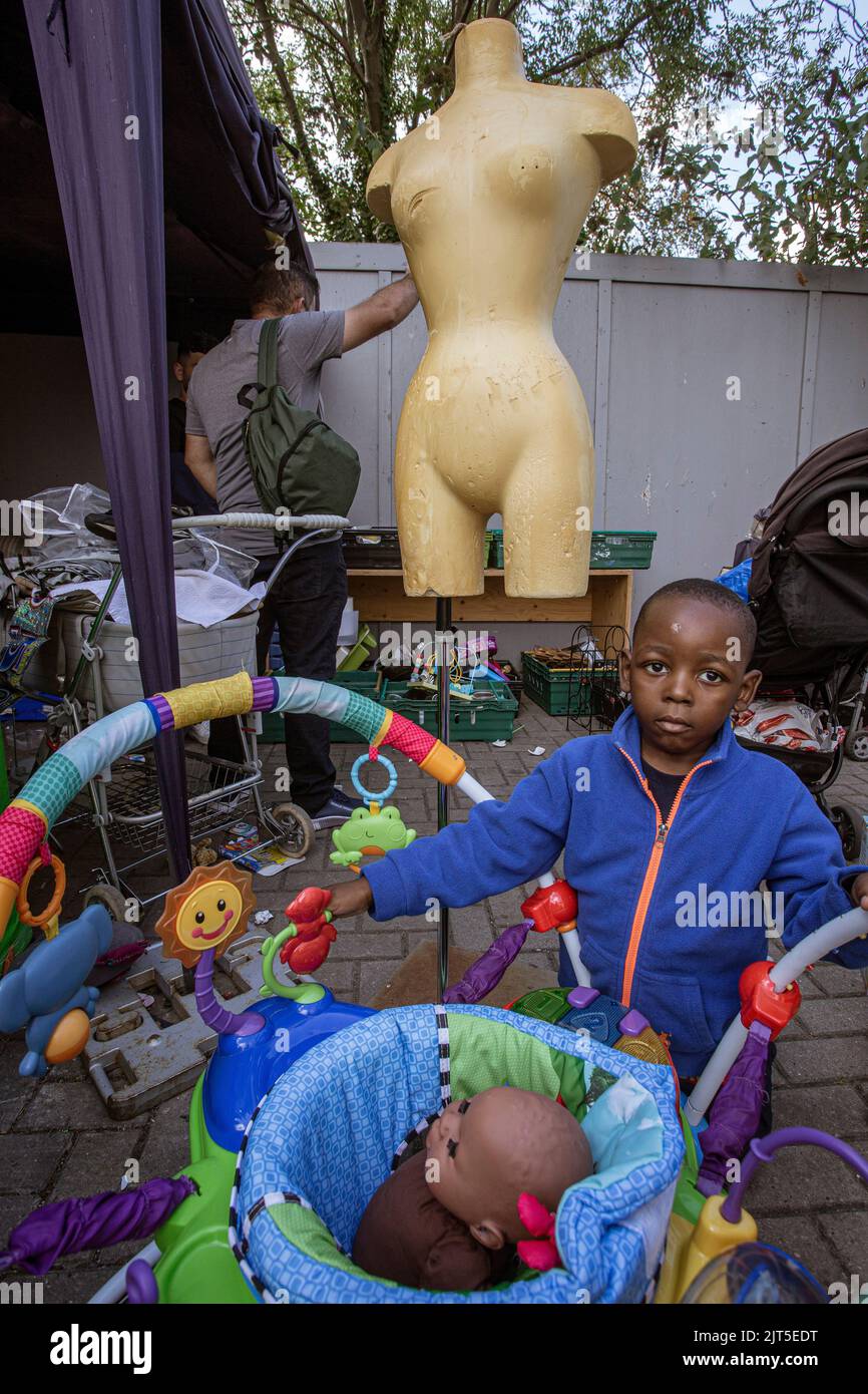 Kleiner Junge auf der Suche nach Spielzeug und Kleidung im Lewisham Donation Hub in London, England Stockfoto