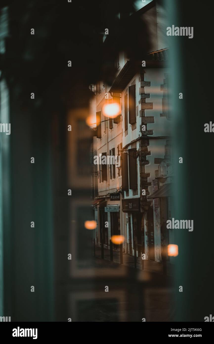 Eine vertikale Aufnahme eines Gebäudes in Saint Jean De Luz in der Nacht aus einem Café Stockfoto