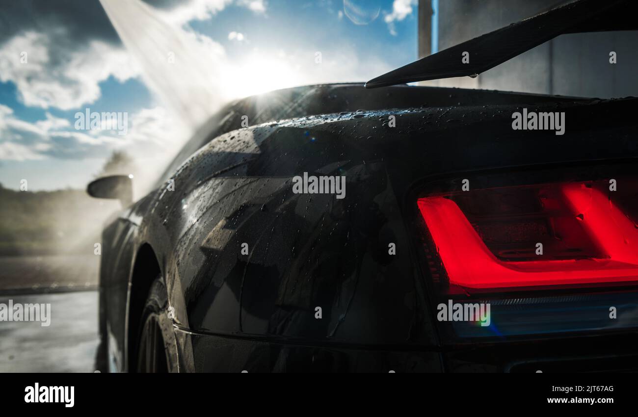 Moderne schwarze Sportwagen in einem Auto Wash. Fahrzeug Druck Waschen und Reinigen. Stockfoto