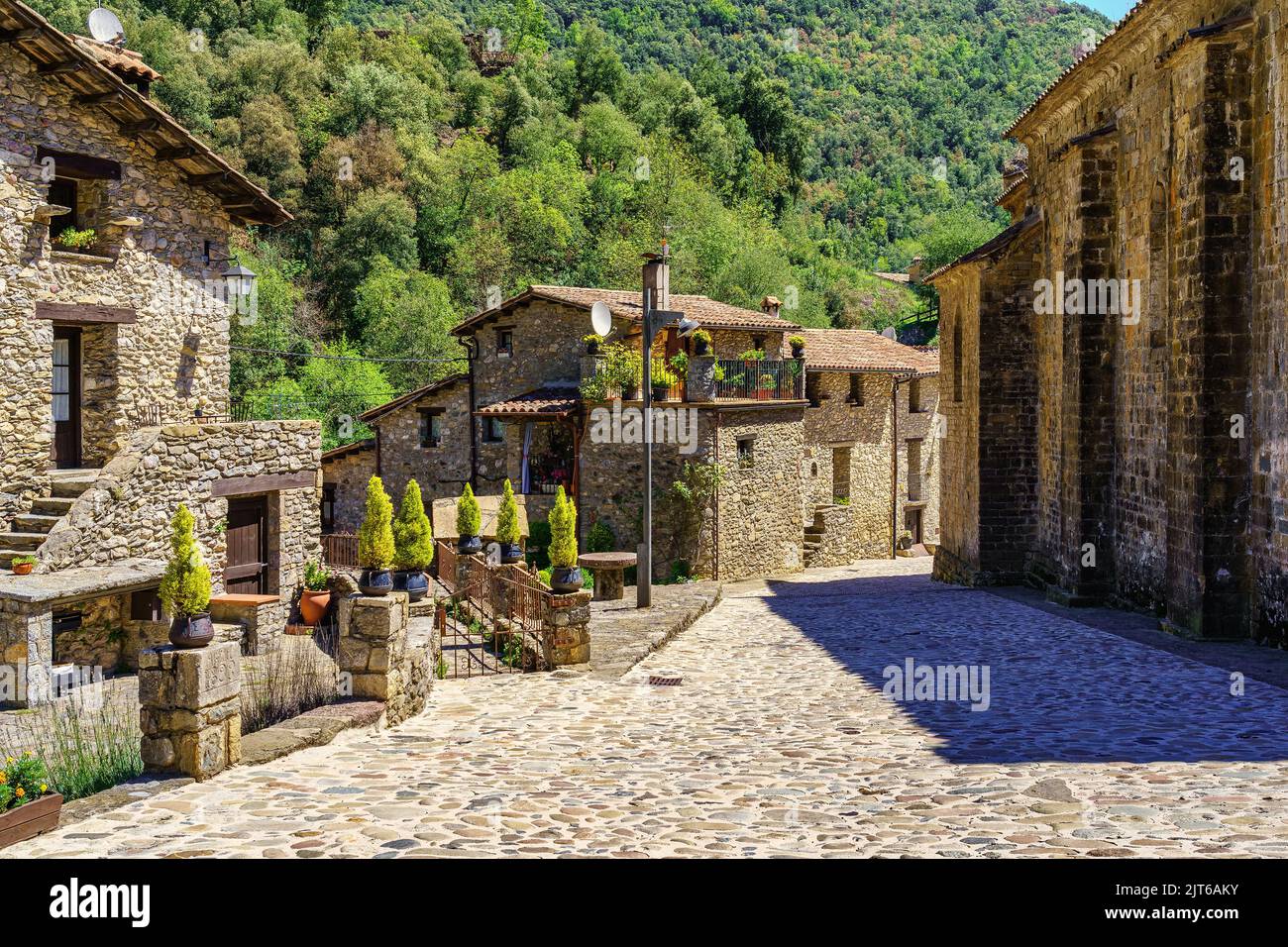 Alte Häuser aus Stein mit Blumen und dekorativen Objekten in dem hübschen Dorf Beget, Girona, Spanien. Stockfoto