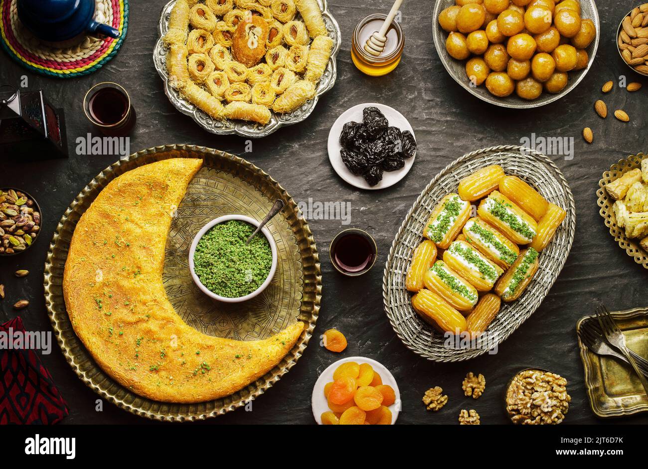 Arabische Küche: Desserts aus dem Nahen Osten. Köstliche Sammlung von traditionellen Ramadan Desserts. Serviert mit leckeren Nüssen, getrockneten Früchten und Honigsirup. Stockfoto