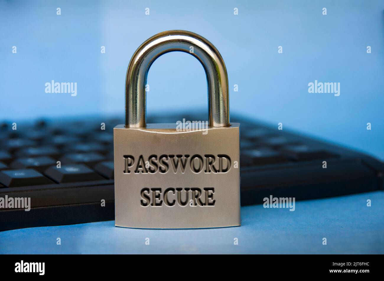Passwortgeschützter Text auf Vorhängeschloss mit verschwommenem Tastaturhintergrund. Passwortsicherheitskonzept. Stockfoto