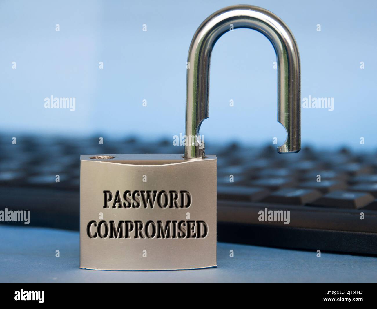 Passwortgefährdete Texte auf dem Vorhängeschloss mit verschwommenem Tastaturhintergrund. Passwortsicherheitskonzept. Stockfoto