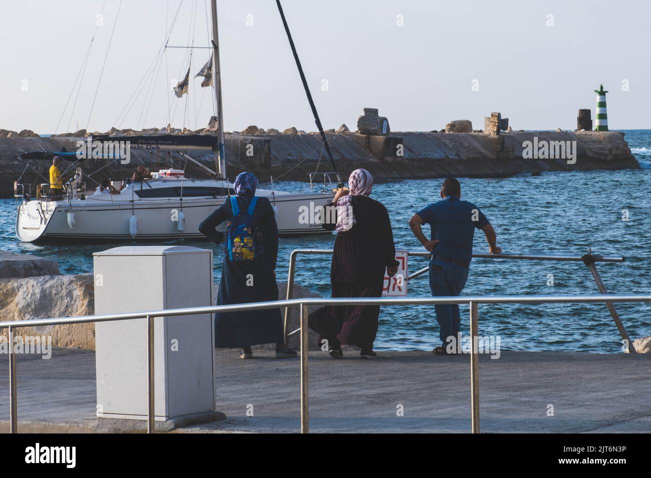 Araber beobachten ein Boot im Hafen von Jaffa Stockfoto
