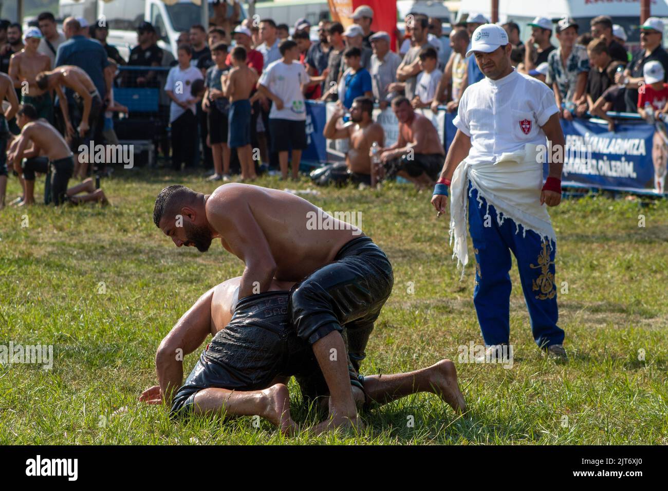 Bursa, Türkei - August 2022: Traditionelle türkische Ölwrestling, Wrestler kämpfen, um ihre Gegner auf dem Gras an heißen, sonnigen Tag zu schlagen, selektive Fokus. Stockfoto