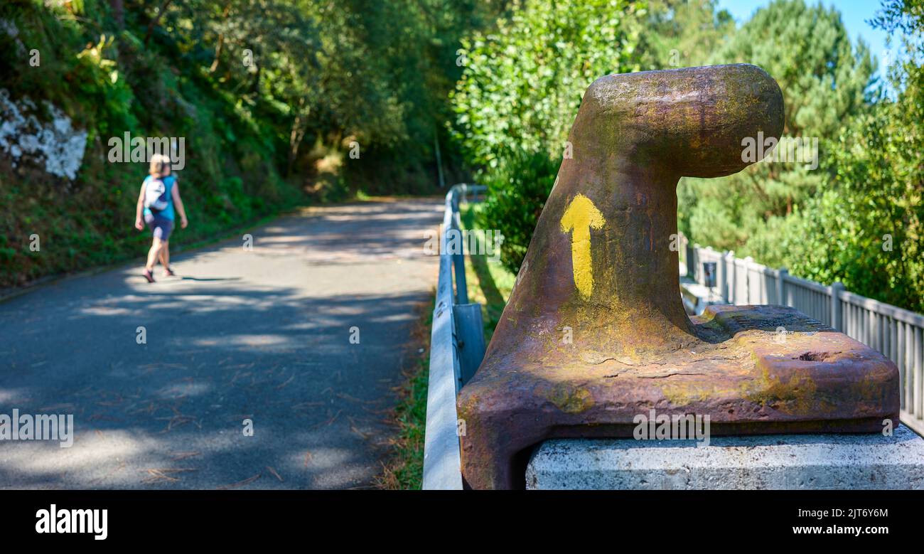 Pilgerfahrt auf dem Jakobsweg, Überquerung vor einem Gelben Pfeil. Stockfoto