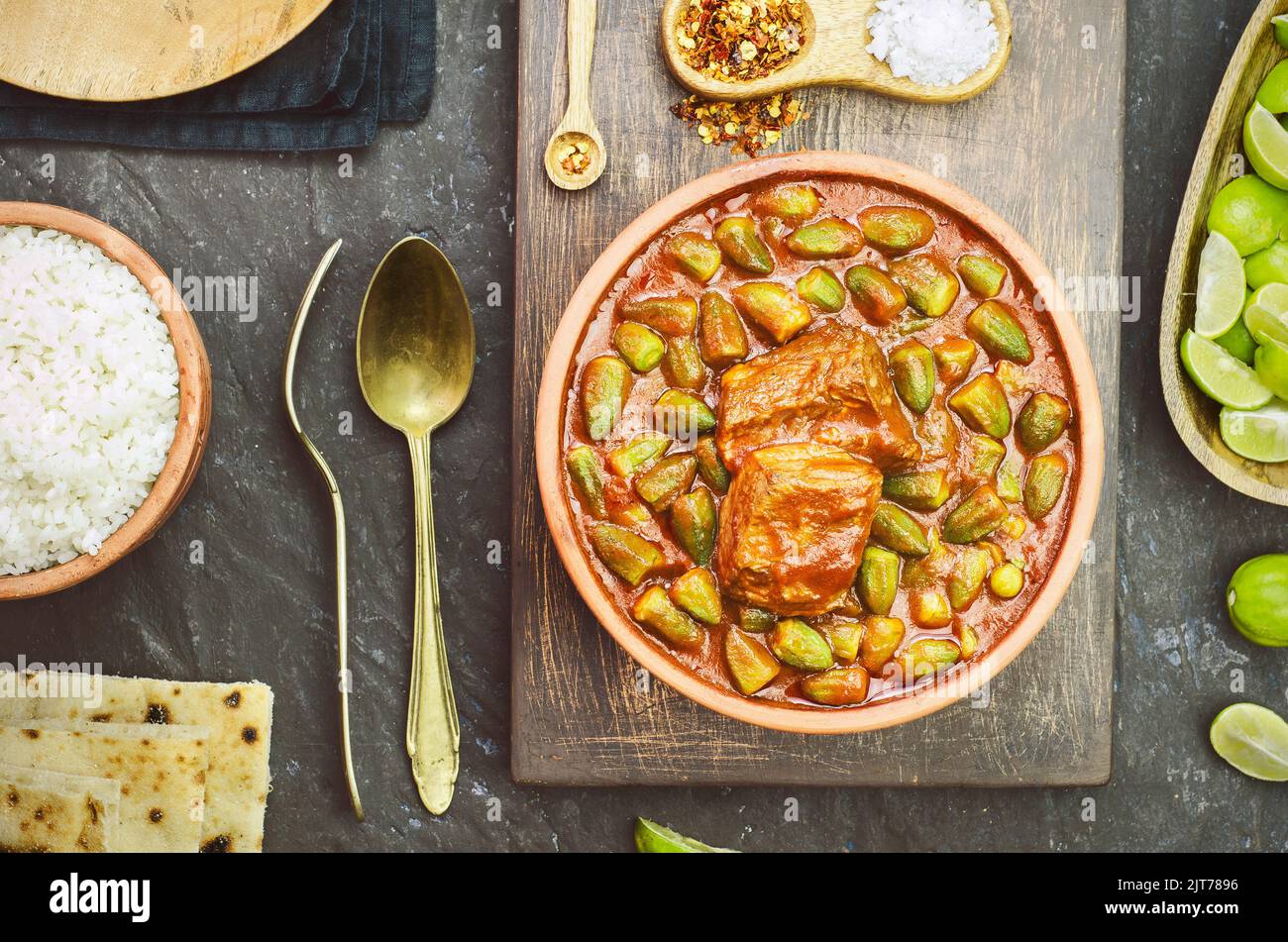 Okra-Eintopf mit einem Stück Rindfleisch und serviert mit weißem Reis, frischem Pitabrot und Zitrone. Es ist ein traditionelles ägyptisches, griechisches, türkisches und rumänisches Gericht. Stockfoto