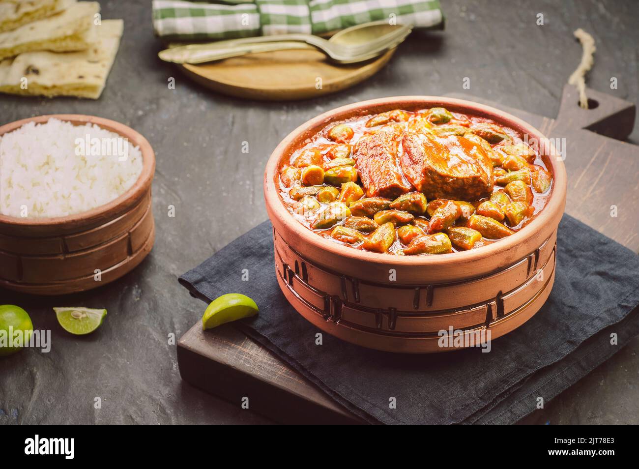 Okra-Eintopf mit einem Stück Rindfleisch und serviert mit weißem Reis, frischem Pitabrot und Zitrone. Es ist ein traditionelles ägyptisches, griechisches, türkisches und rumänisches Gericht. Stockfoto