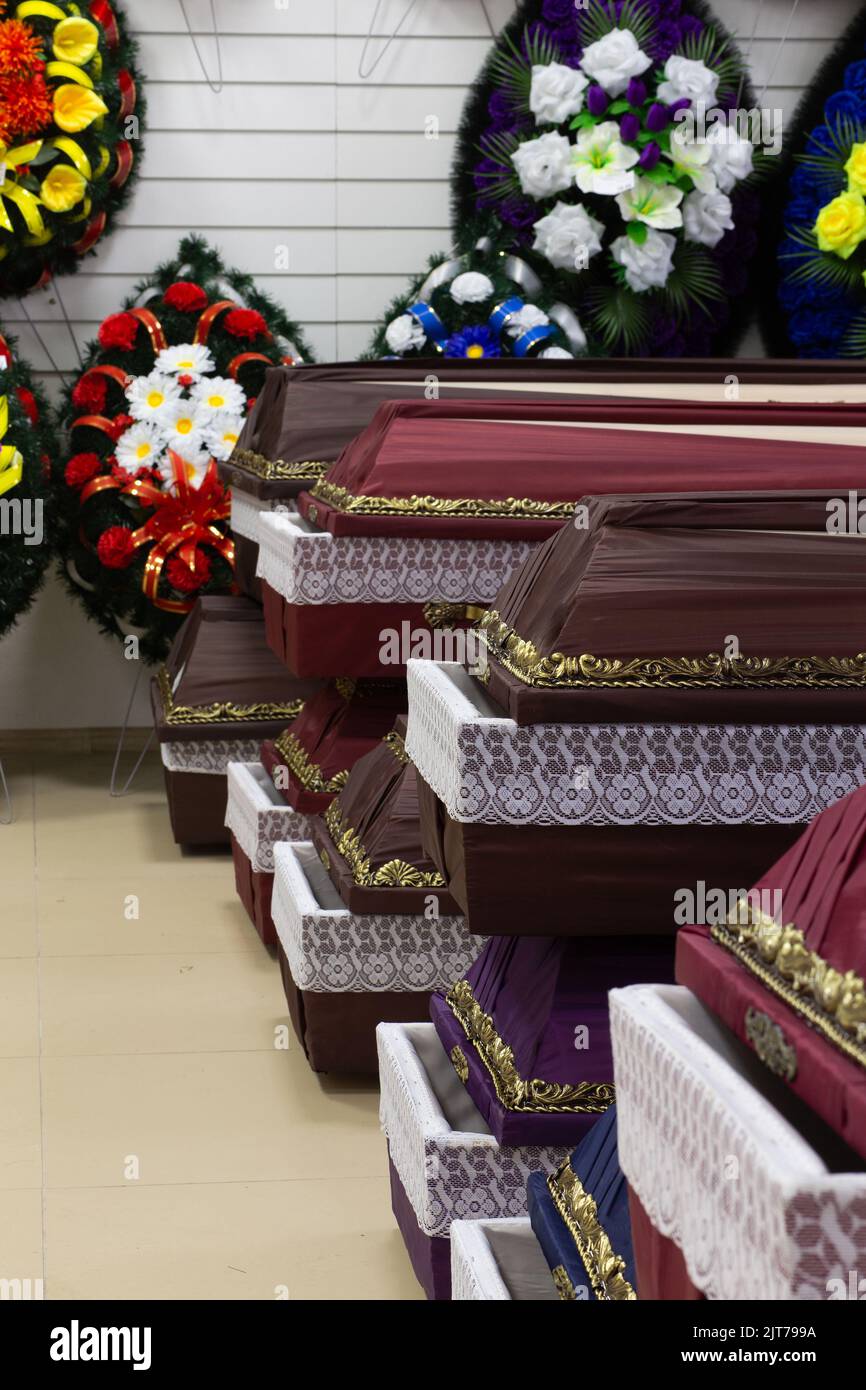 Innenraum des Raumes mit Bestattungszubehör. Geschäft mit Särgen, Beerdigungskränzen und Blumen. Stockfoto