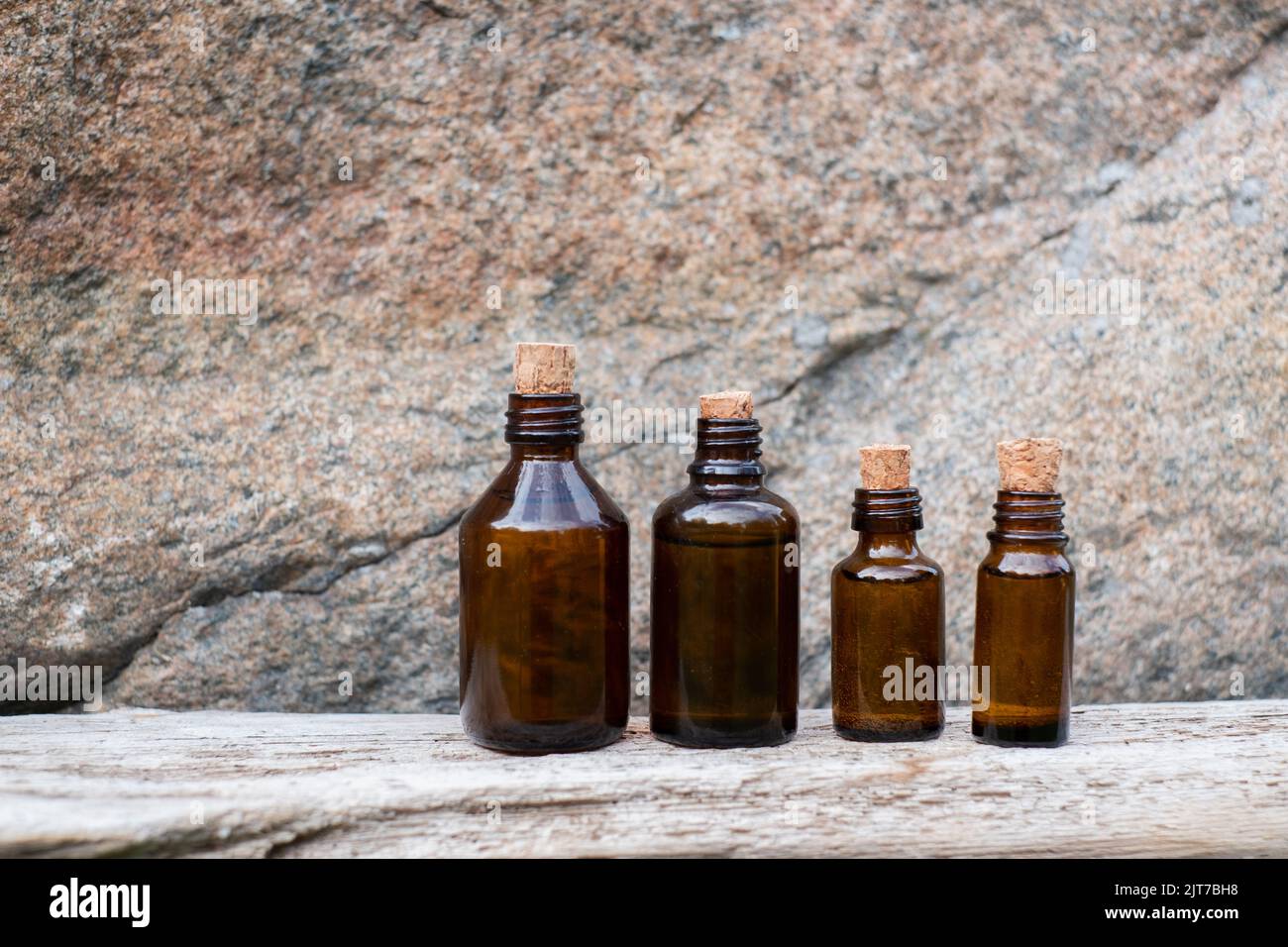 Kleine braune Glasflasche mit Medikamenten auf veraltertem Holzhintergrund. Stockfoto