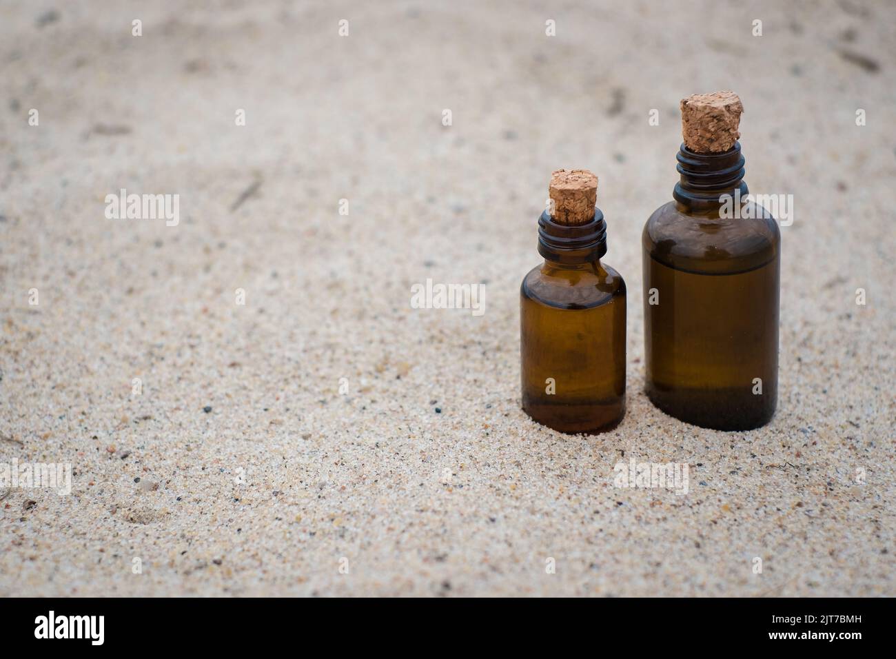 Kleine braune Medizinflasche auf beigem Sandhintergrund. Leerer Kopierbereich. Stockfoto