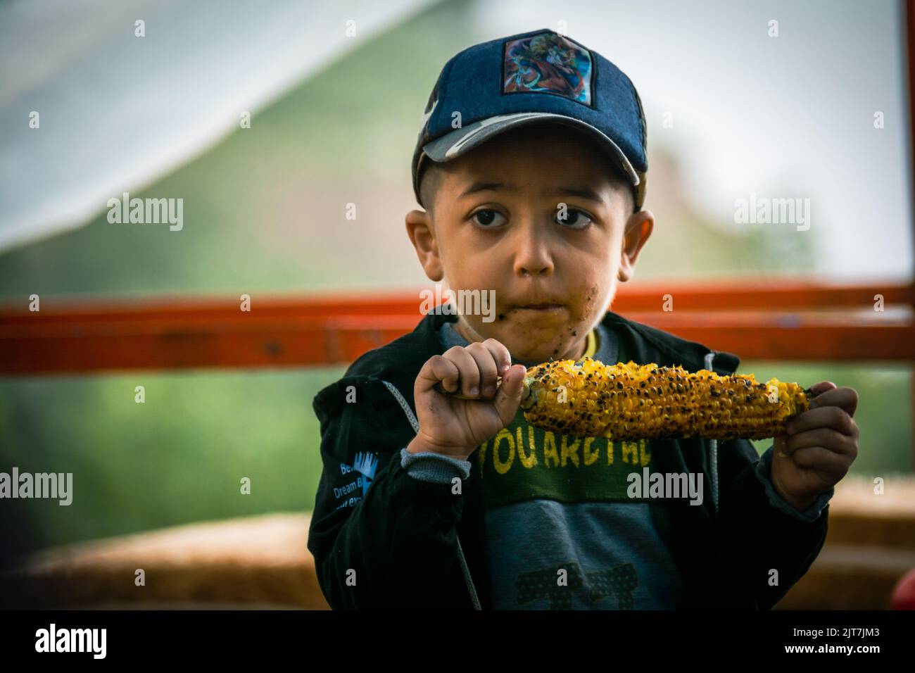 Junge, der Mais mit Leidenschaft isst Stockfoto