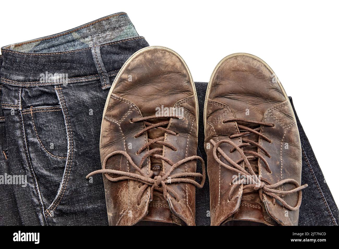 Stilvoll verzweifelte Vintage braune Lederschuhe und schwarze Jeans auf weißem Hintergrund isoliert Stockfoto