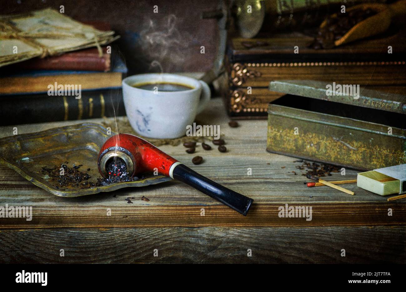 Klassisches Stillleben mit Vintage-Pfeife, platziert mit Tabak, einer Tasse Kaffee, alten Büchern, Kaffeemühle und Kaffeebohnen auf rustikalem Holzhintergrund. Stockfoto