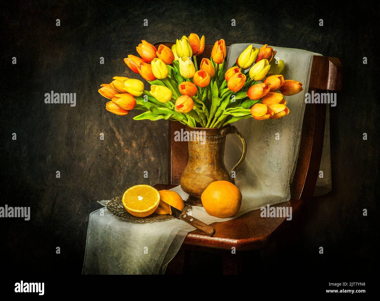 Klassisches Stillleben mit Blumenstrauß aus Tulpen auf rustikalem Holzstuhl mit frischen Orangen, Vintage-Messer und Schal platziert. Stockfoto