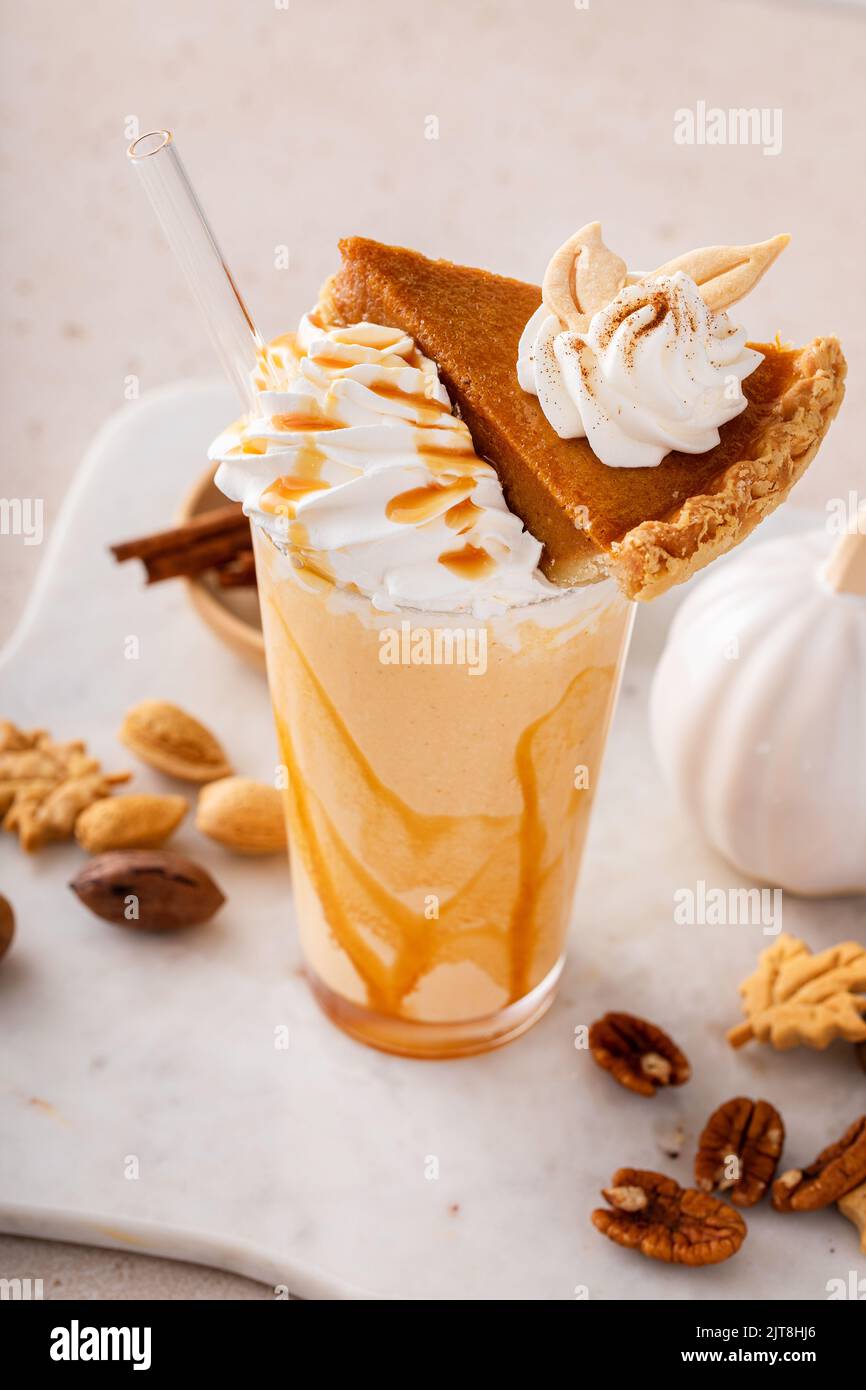 Kürbiskuchen-Milchshake mit Karamellsirup und Schlagsahne Stockfoto