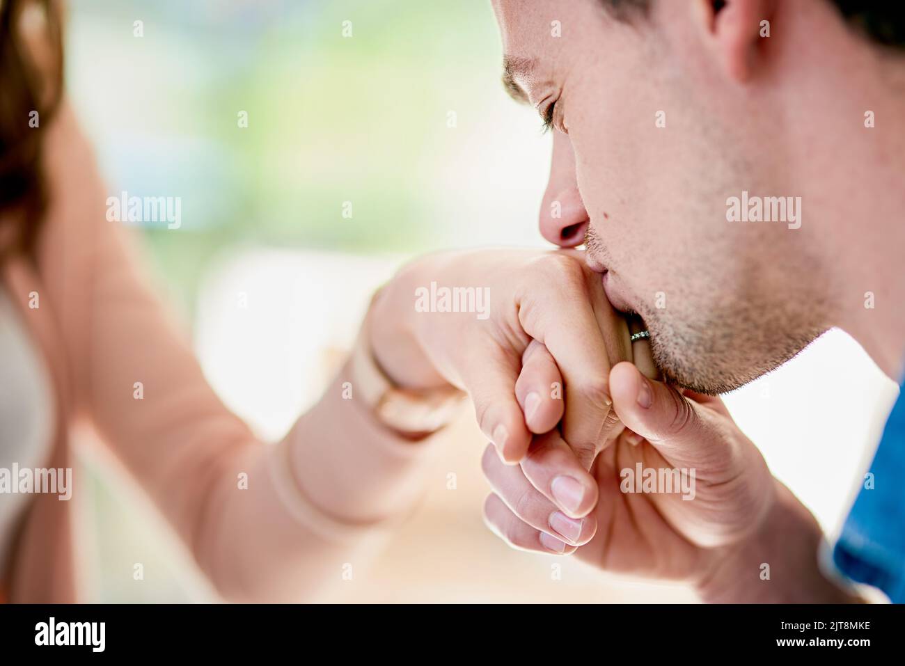 Ich gebe mein Leben für dich. Nahaufnahme eines jungen Mannes, der seine Verlobten in die Hand küsst. Stockfoto