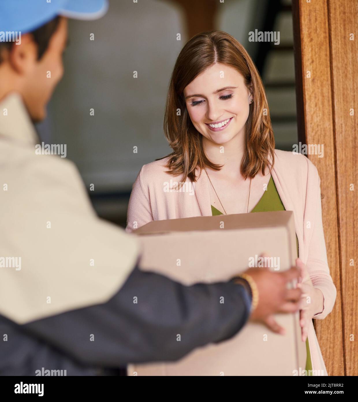 Ein weiteres Paket sicher an einen zufriedenen Kunden geliefert. Ein Kurier, der eine Lieferung an einen Kunden zu Hause macht. Stockfoto