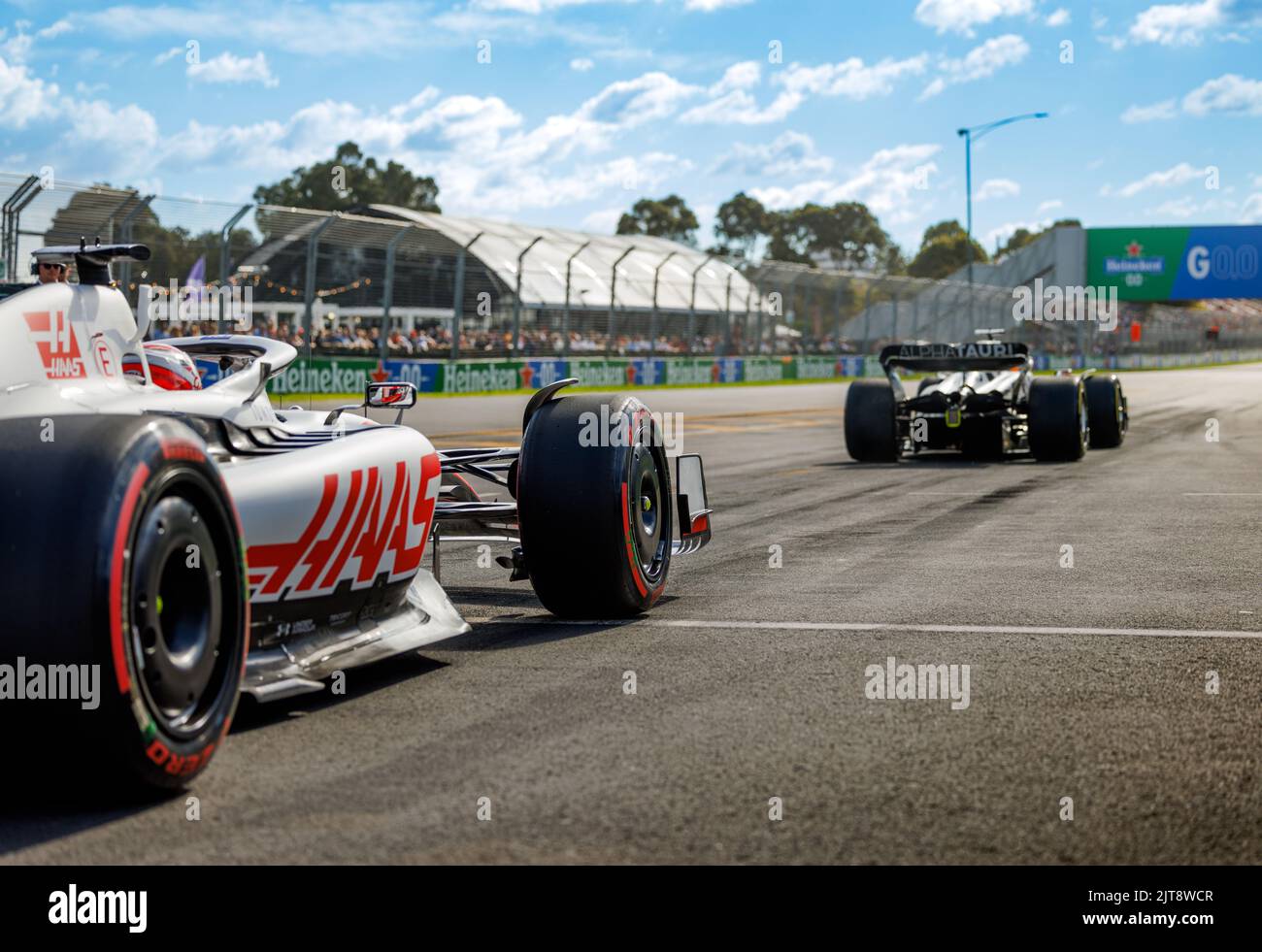 Ein HAAS-Auto steht bei einem Boxenbahnenstart beim Australian Formel 1 Grand Prix 2022 im Albert Park hinter einem Alpha Tauri Stockfoto