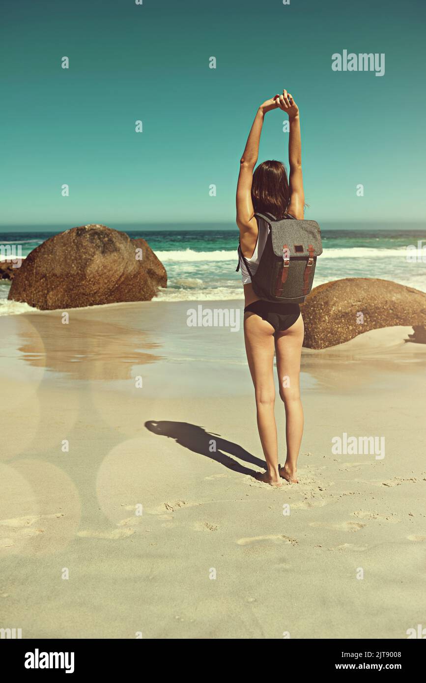 Nichts ist besser als schöne Orte zu erkunden. Ein junger Backpacker bewundert die wunderschöne Landschaft am Strand. Stockfoto