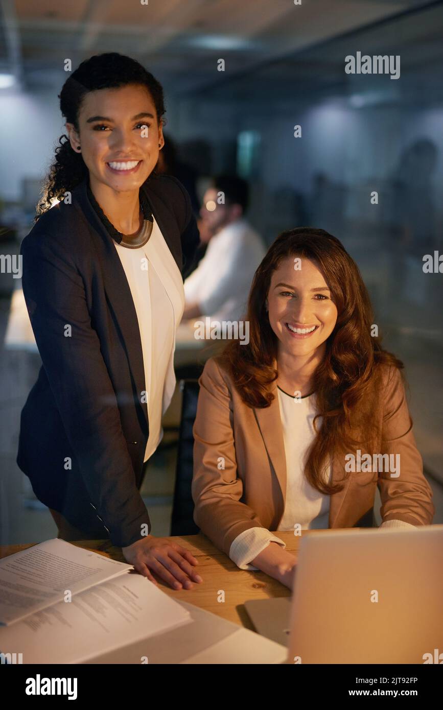 Tun Sie alles, um die Arbeit zu erledigen. Porträt von zwei Geschäftsfrauen, die im Büro gemeinsam Überstunden machen. Stockfoto