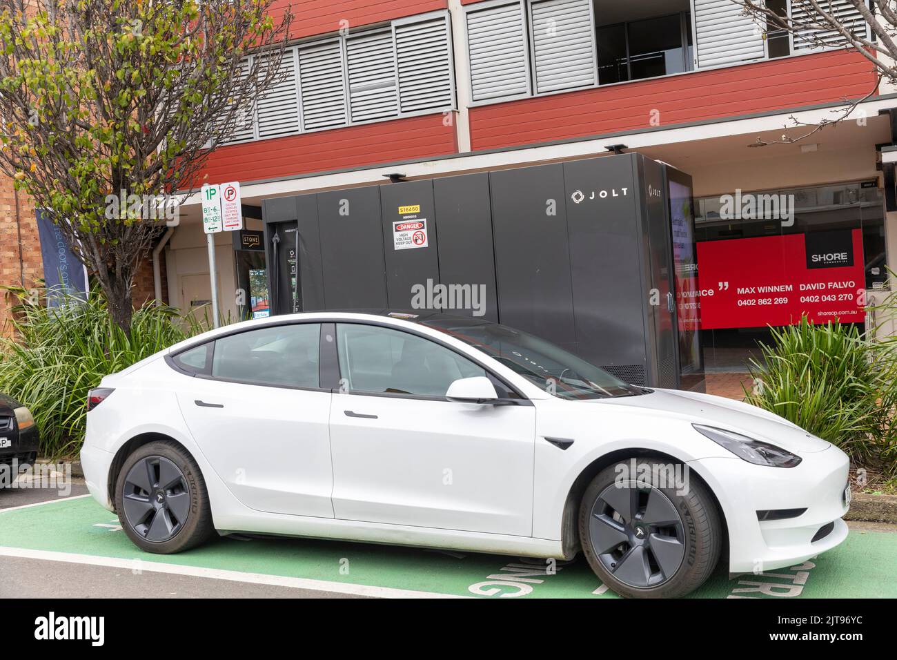 Tesla Model 3 EV-Fahrzeug in Mona Velle, Sydney, auf einem öffentlichen Jolt EV-Ladegerät, das aufgeladen wird, NSW, Australien Stockfoto