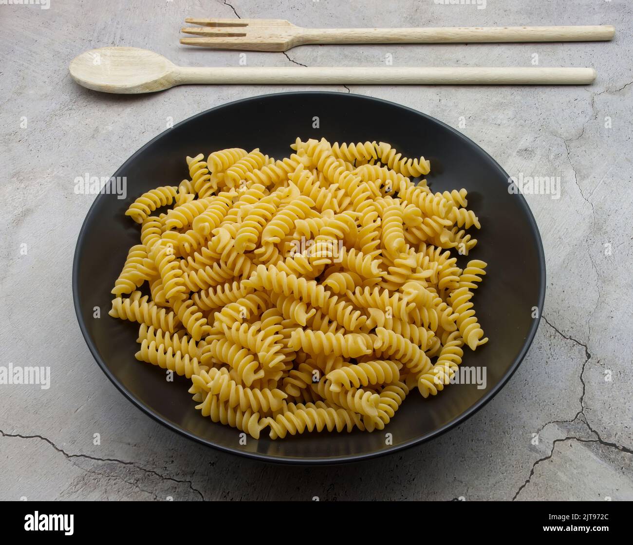 Rohe italienische Fusilli Pasta in einem schwarzen Gericht. Traditionelle italienische Küche. Stockfoto