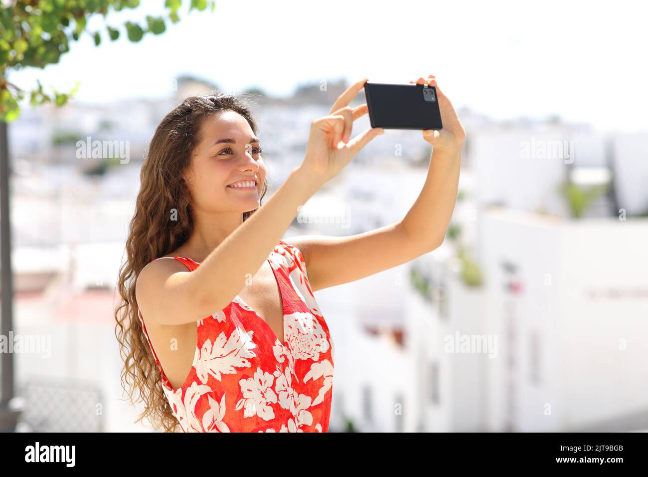 Tourist, der in einer weißen spanischen Stadt mit einem Smartphone fotografiert Stockfoto