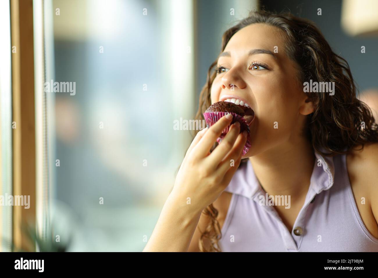 Glückliche Frau, die in einem Restaurant Schokoladenkuchen isst Stockfoto