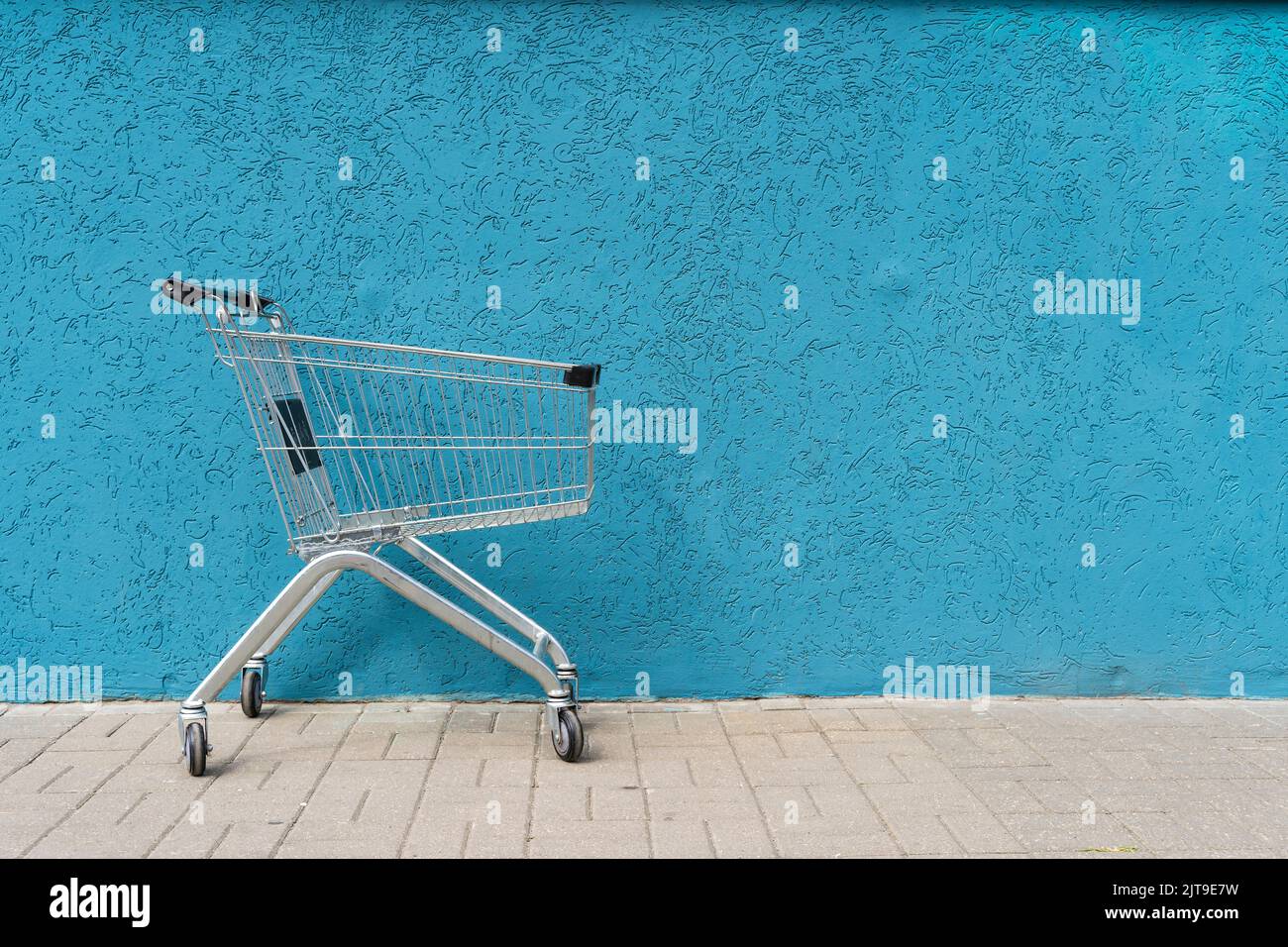 Supermarkt Cart Trolley auf leeren farbigen Wand Hintergrund. Retail, Sale, Shopping-Konzept. Hochwertige Fotos Stockfoto