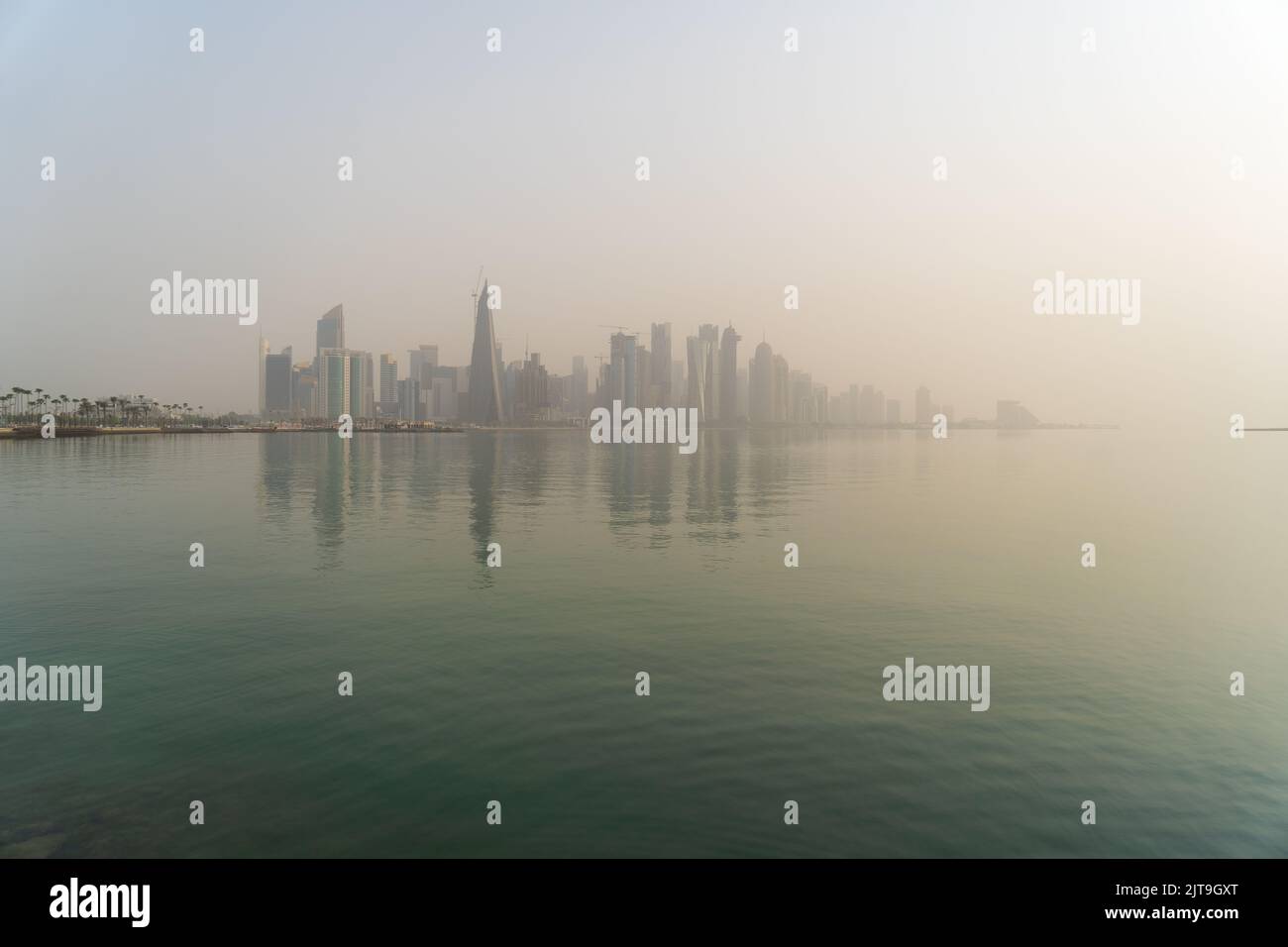 Skyline von Doha bei Sonnenaufgang mit Morgennebel Stockfoto