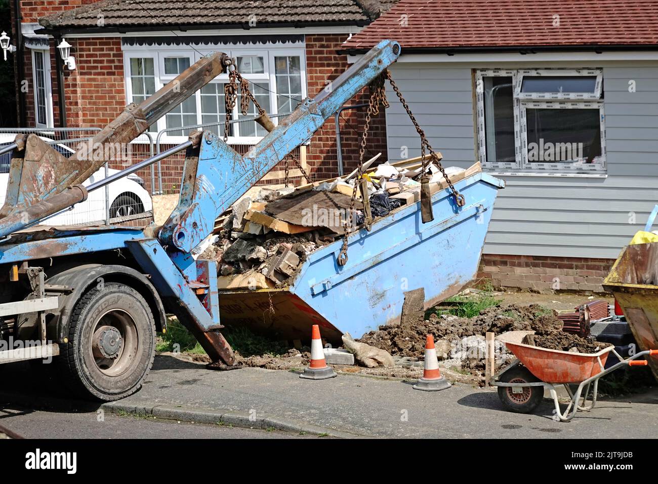 Der Mülltonne des Bauherrn wurde von der Baustelle des kompakten Bungalowgebäudes auf den lastwagen skip für die Abfuhr zur Deponie England UK gehoben Stockfoto