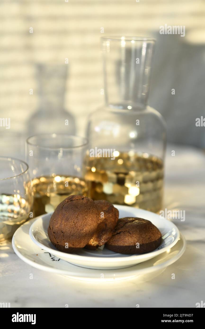 Eine vertikale Nahaufnahme von köstlichen Keksen, serviert mit Tassen Saft auf dem Tisch Stockfoto