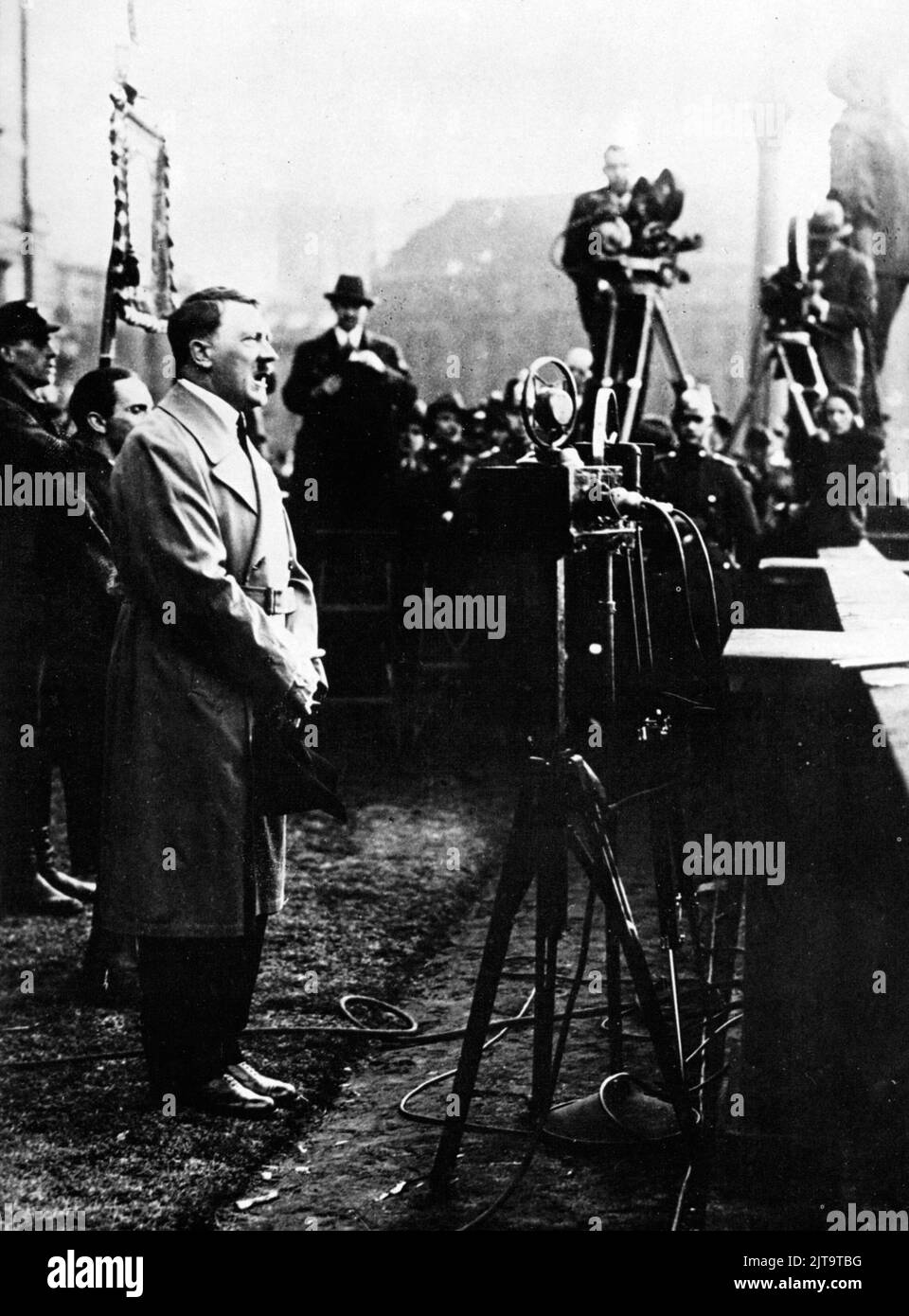 Ein Vintage-Foto um 1933, das den deutschen Nazi-Diktator Adolf Hitler zeigt, der sich während einer Wahlkampfveranstaltung an Menschenmengen wendet Stockfoto