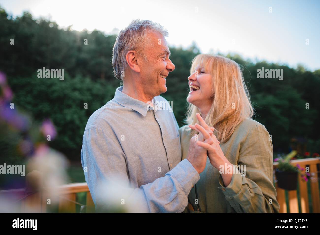 Porträt eines liebevollen Seniorenpaares, das zu Hause Zeit zusammen verbringt und im Garten tanzt. Stockfoto