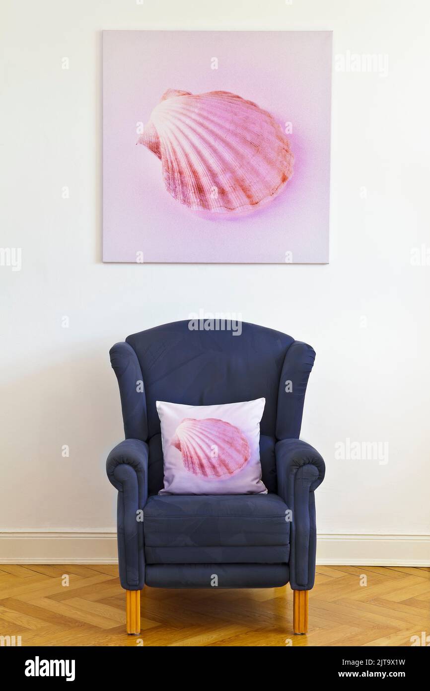 Erstellen Sie Ihr eigenes Kunstkonzept: Quadratischer Leinwanddruck eines rosa Muschelbildes und ein blauer Ohrensessel mit einem Wurfkissen desselben Fotos. Stockfoto