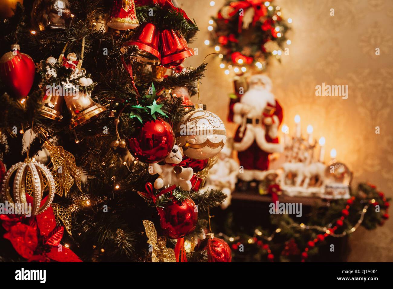 Weihnachtsbaum mit Spielzeug auf dem Hintergrund des Kamins im Inneren des Hauses. Stockfoto