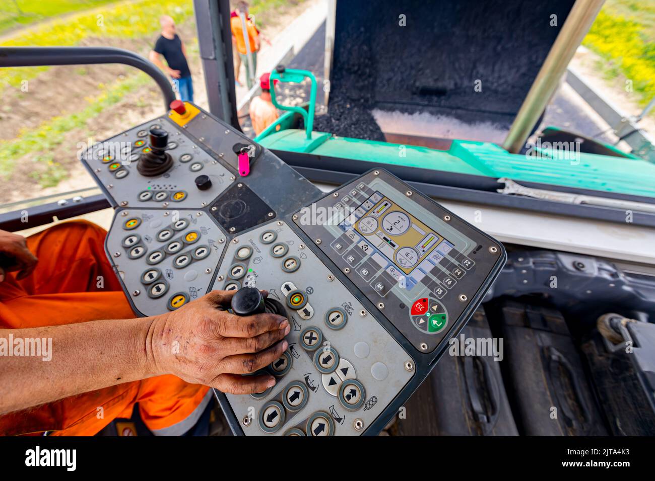 Arbeiter, Fahrer steuert Asphalt Straße Verlegemaschine mit Lenker, Joystick zu bedienen. Stockfoto