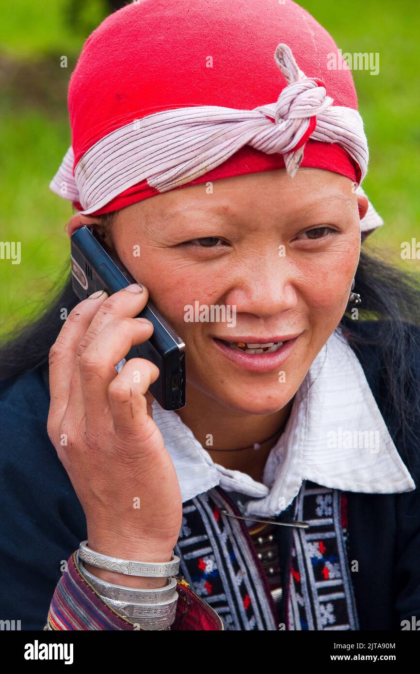 In der nördlichen Stadt Sapa benutzt die Frau des Stammes der Roten Dao, Vietnam, ihr Mobiltelefon. Stockfoto