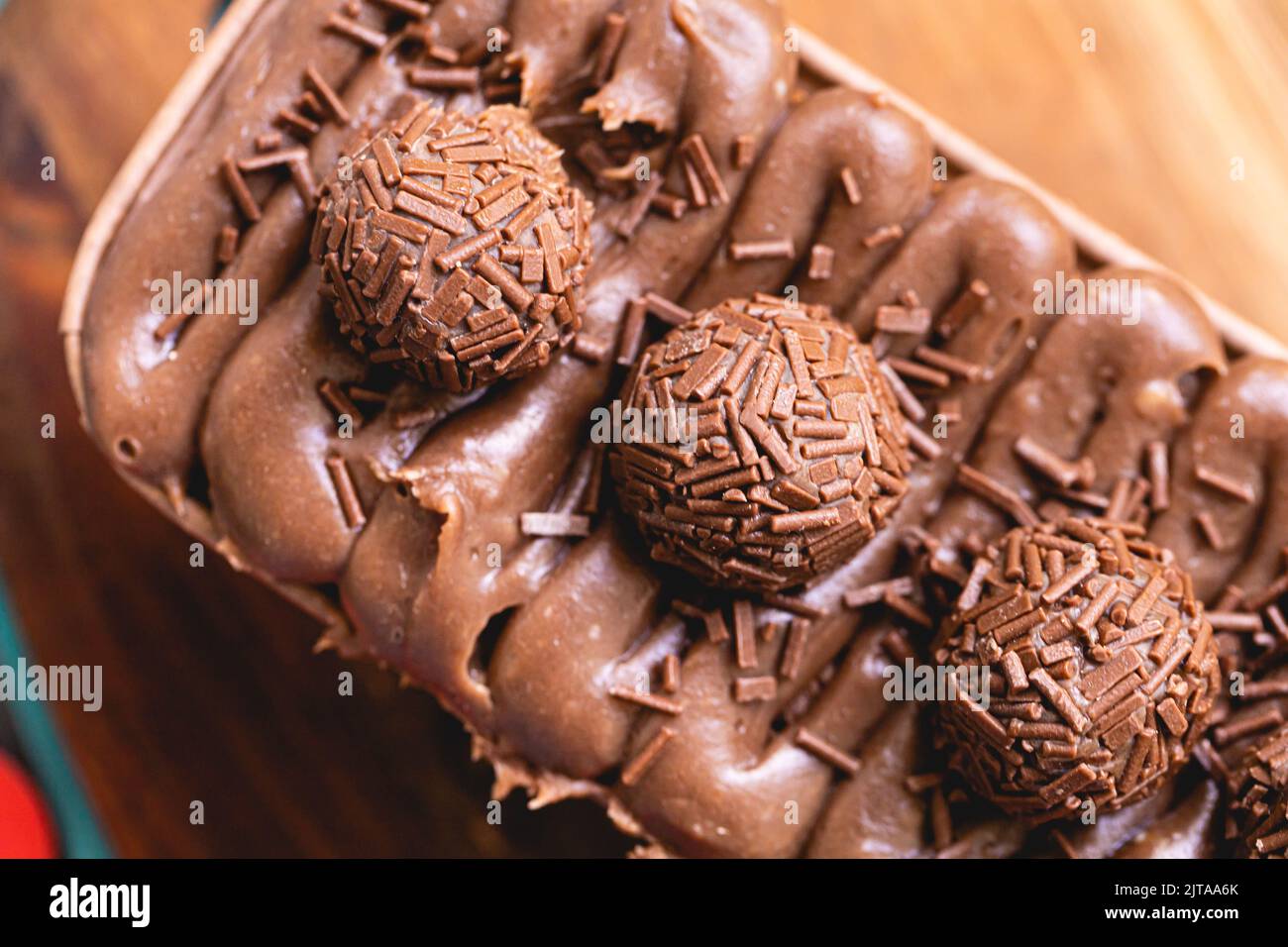 Kuchen namens Brigadeiro Caseirhiro. Schokoladenkuchen mit Schokoladenfrosting und Brigadierern zum Dekorieren. Süßwaren, Dessert. Stockfoto