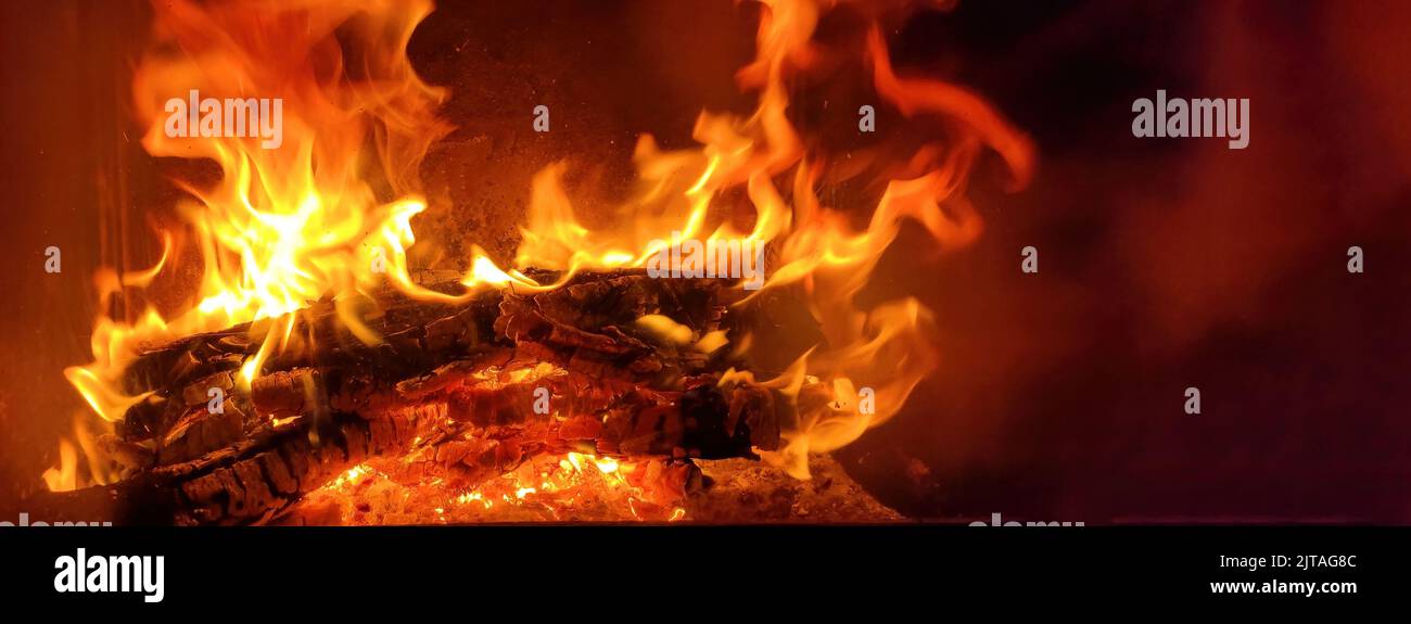Ein Holzholz, das in einem Kamin brennt, ein Feuer von oranger Farbe, Wärme von Zuhause im Herbst Stockfoto