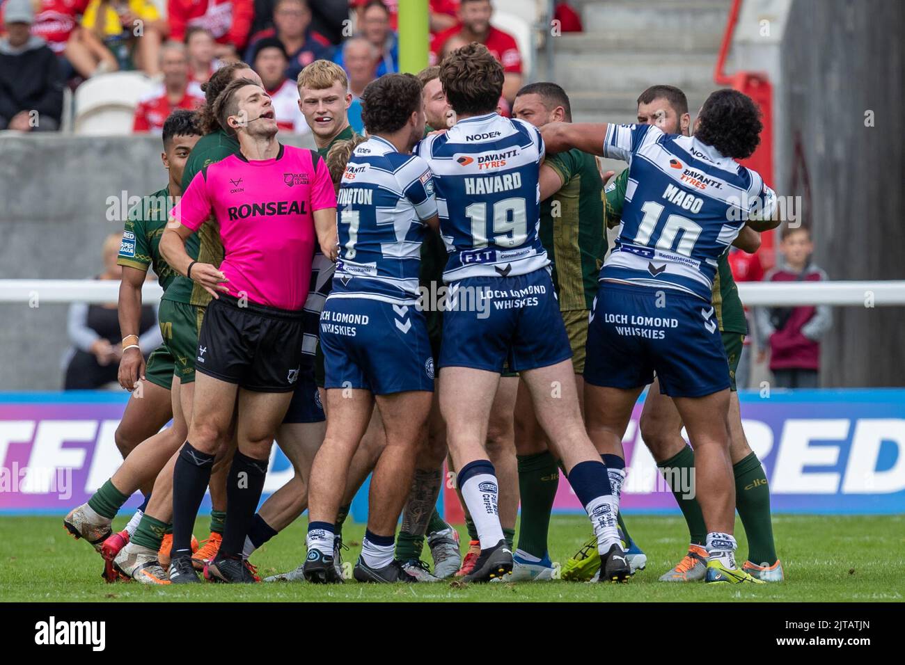 Nachdem Oliver Partington #17 von Wigan Warriors ein High-Tackle durchführt, bricht ein Gestreich zwischen den beiden Teams aus Stockfoto