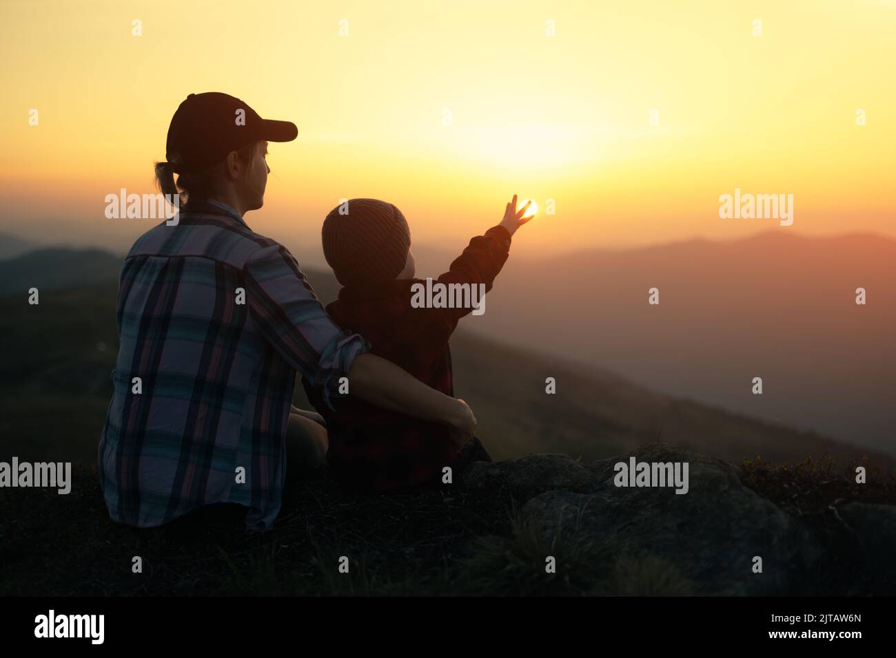 Mama mit Sohn in den Herbstbergen während des Sonnenuntergangs. Reise mit Kind Konzept Stockfoto