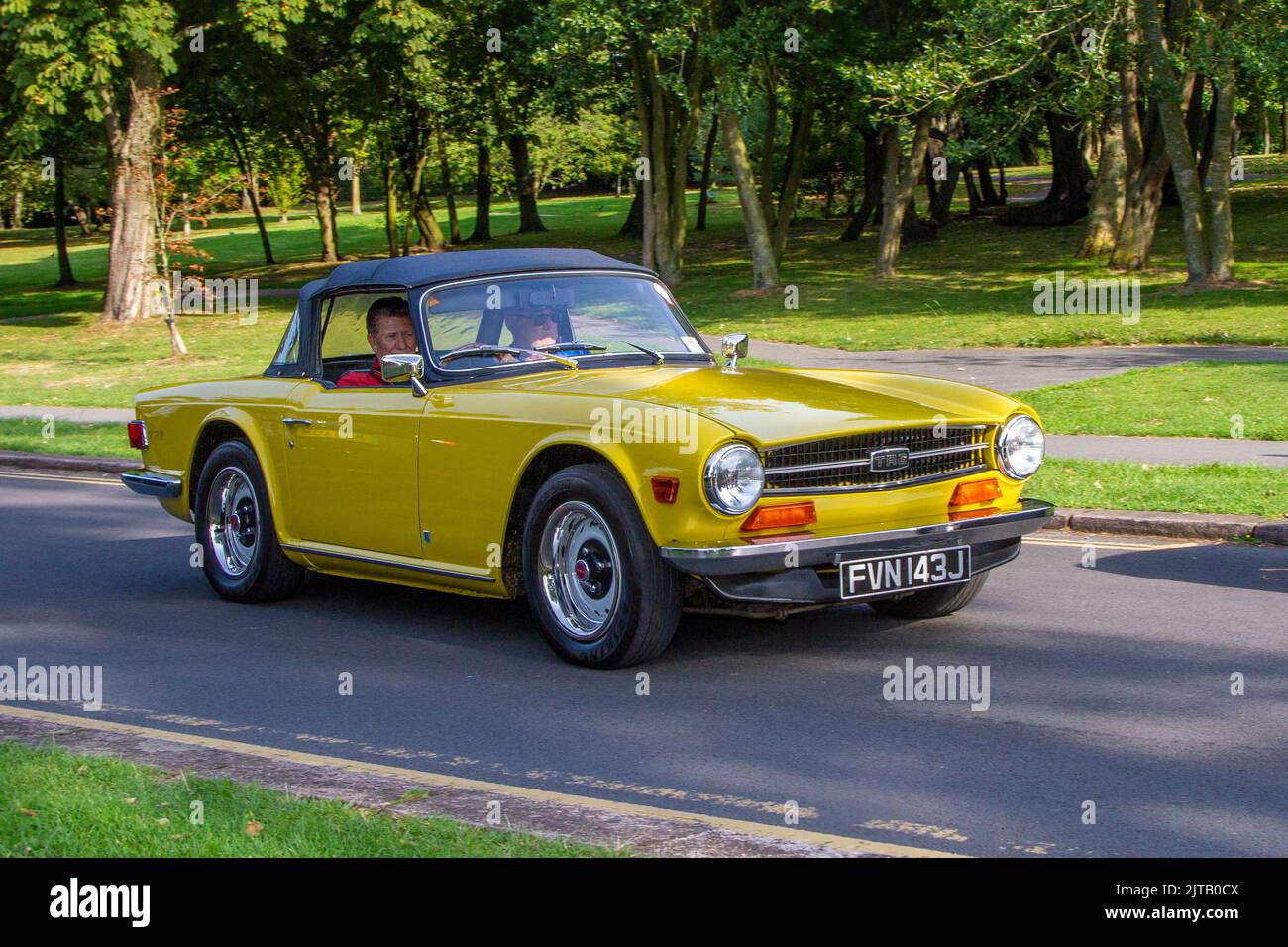 1971er Jahre, 70er Jahre, gelber TRIUMPH TR6 2500 ccm Benziner britischer Sportwagen, der auf der jährlichen Stanley Park Classic Car Show in den Parkgärten ankommt. Stanley Park Classics Youryear Motor Show veranstaltet von Blackpool Vintage Vehicle Preservation Group, Großbritannien. Stockfoto