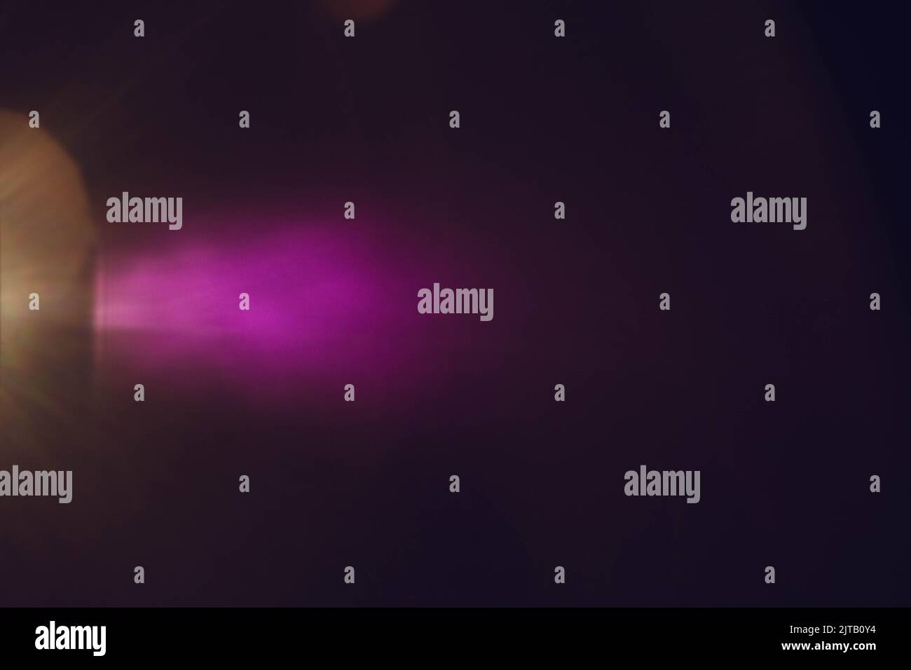scheinwerferstrahl mit violettem, dunklem Hintergrund Stockfoto