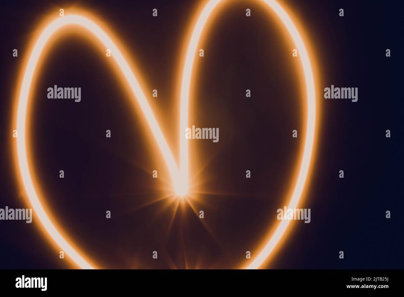 Die Beleuchtung der Herzspur verwischt orange beleuchtete Linien Stockfoto