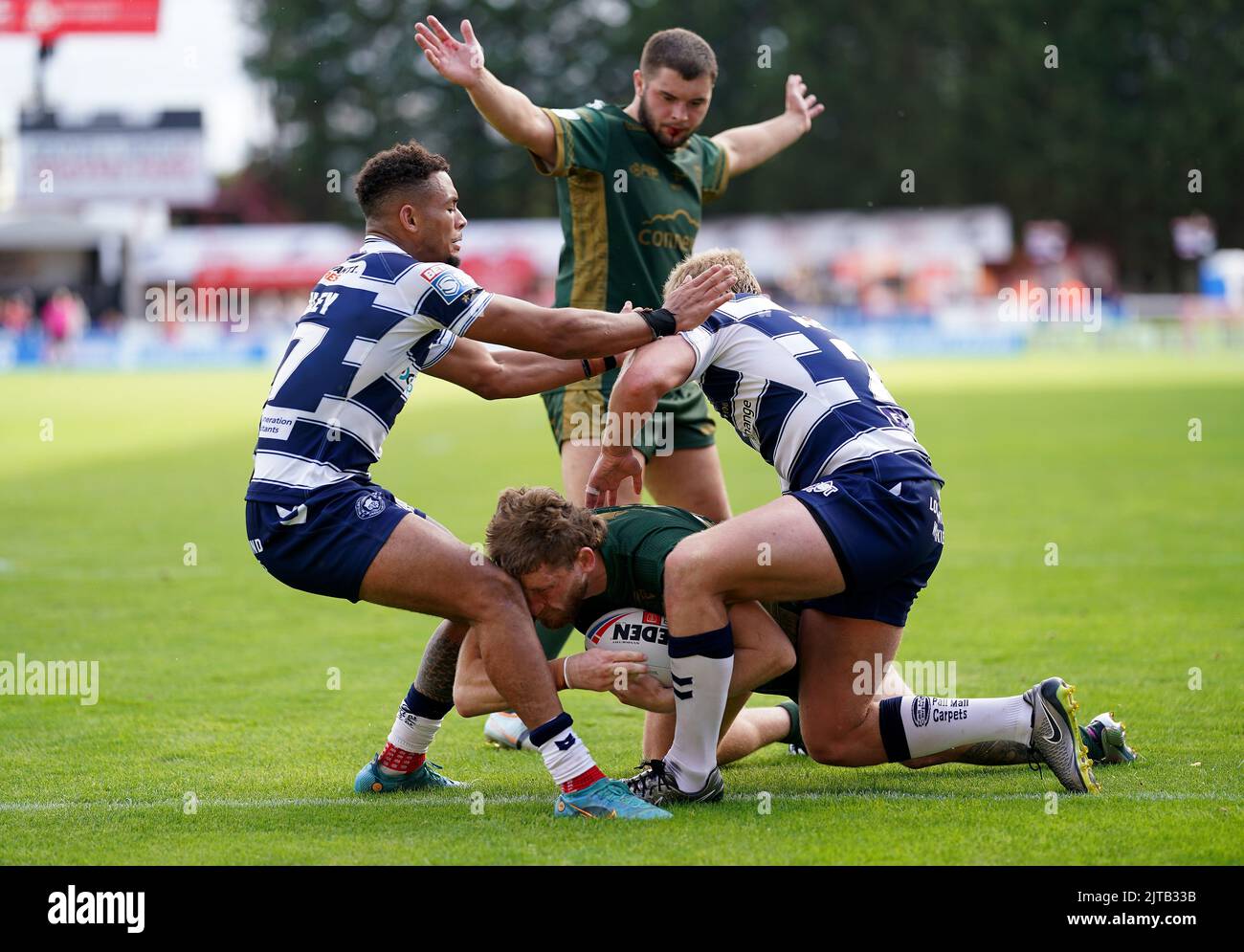 Hull Kingston Rovers' Ethan Ryan (Mitte) gibt einen Versuch ab, aber während des Betfred Super League-Spiels im Sewell Group Craven Park, Kingston upon Hull, macht Umyla Hanley von Wigan Warriors (links) ein Knie im Gesicht. Bilddatum: Montag, 29. August 2022. Stockfoto