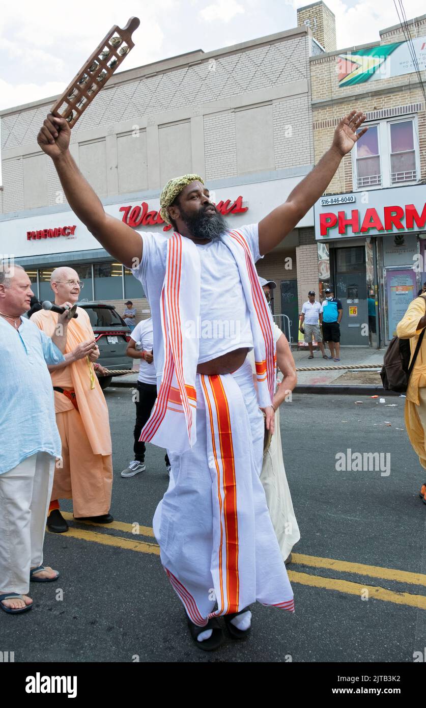 Ein frommer afroamerikanischer Hindu-Mann tanzt und singt auf der Liberty Avenue zur Feier der Ratha Yatra 2022 in Richmond Hill, Queens, NYC Stockfoto