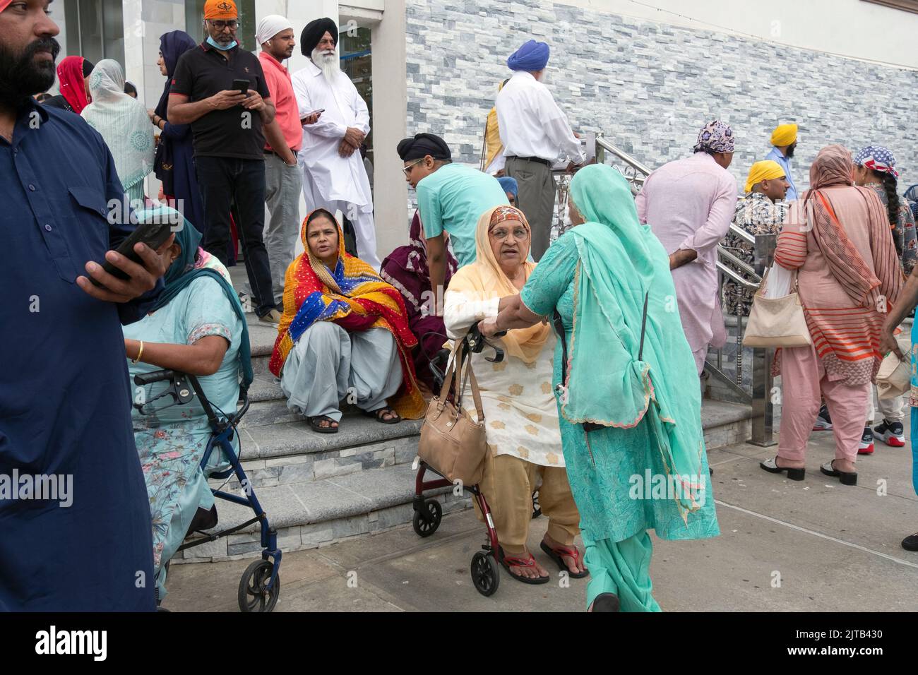 Männer und Frauen vor dem Sikh Cultural Center warten auf den Beginn der Nagar Kirtan Parade in Richmond Hill, Queens, New York City. Stockfoto