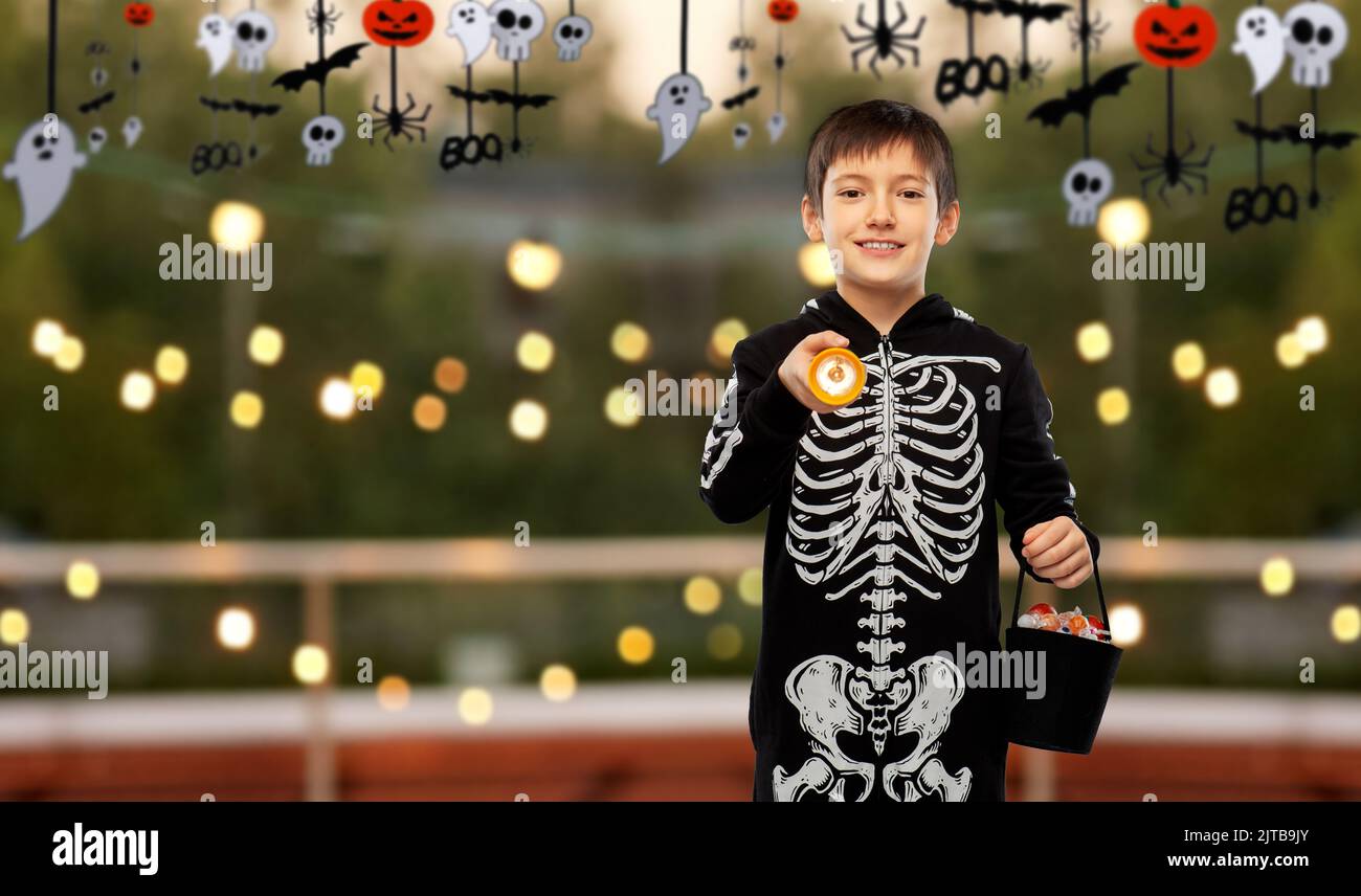 Junge im halloween Kostüm mit Süßigkeiten und Fackel Stockfoto
